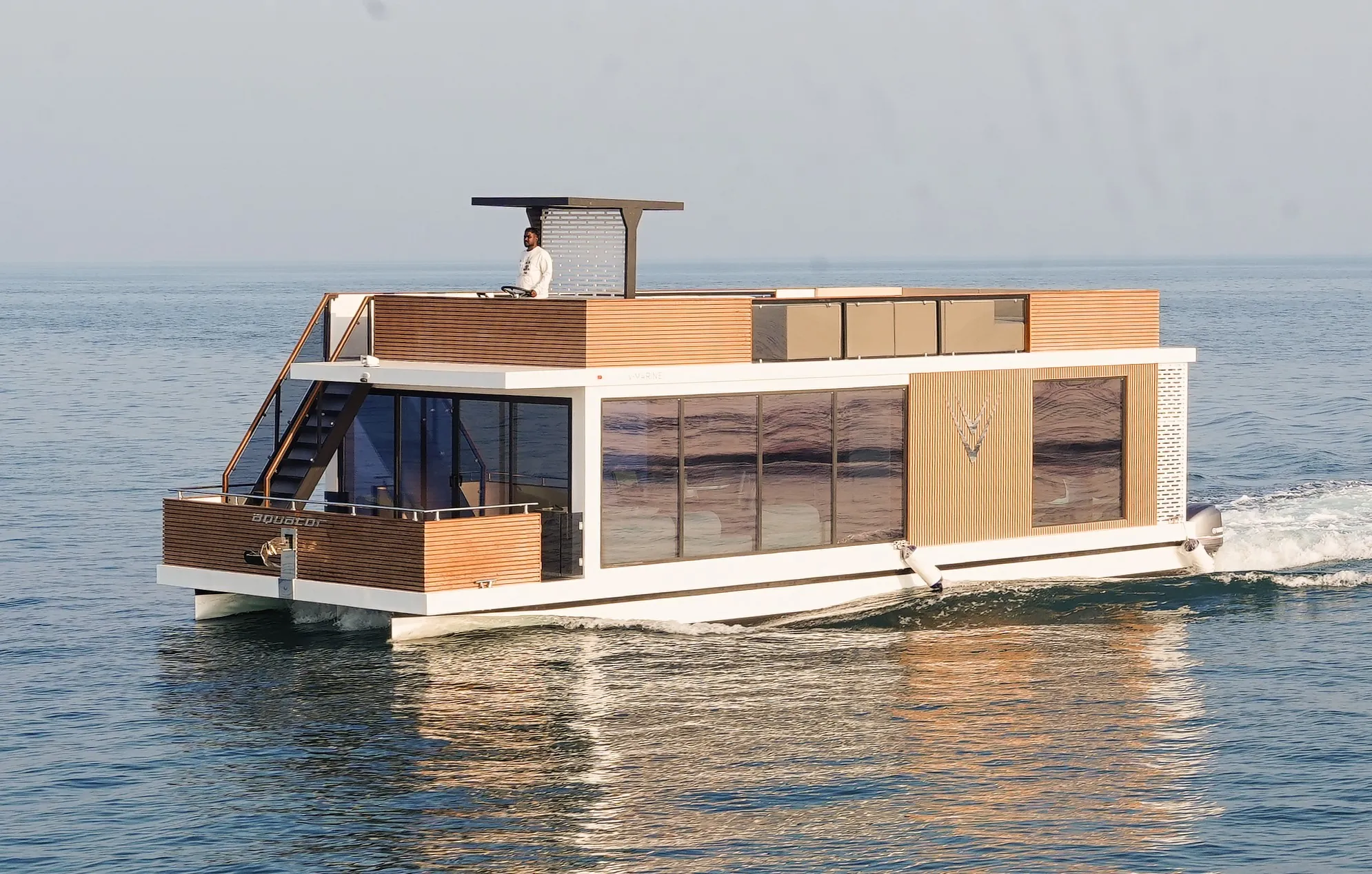 Aquator 50 cruising with its upper-deck terrace and timber cabin