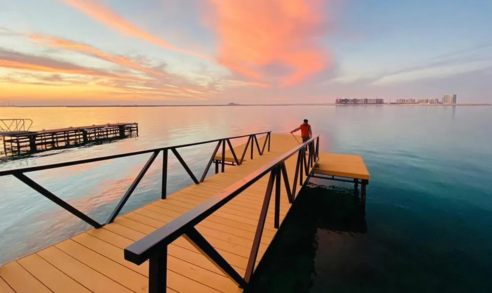 Timber floating jetty stretching into the water at sunset
