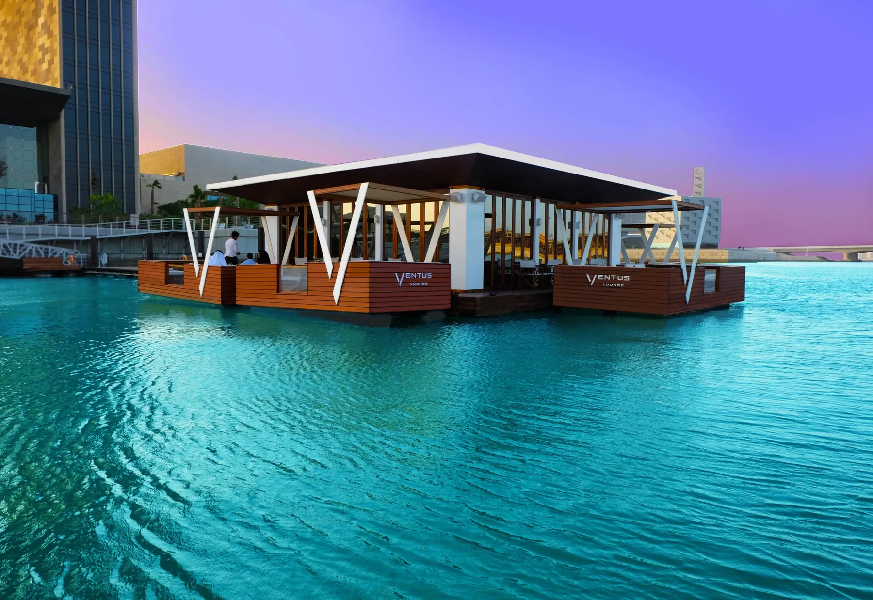 Floating restaurant pavilion on turquoise water with a city skyline