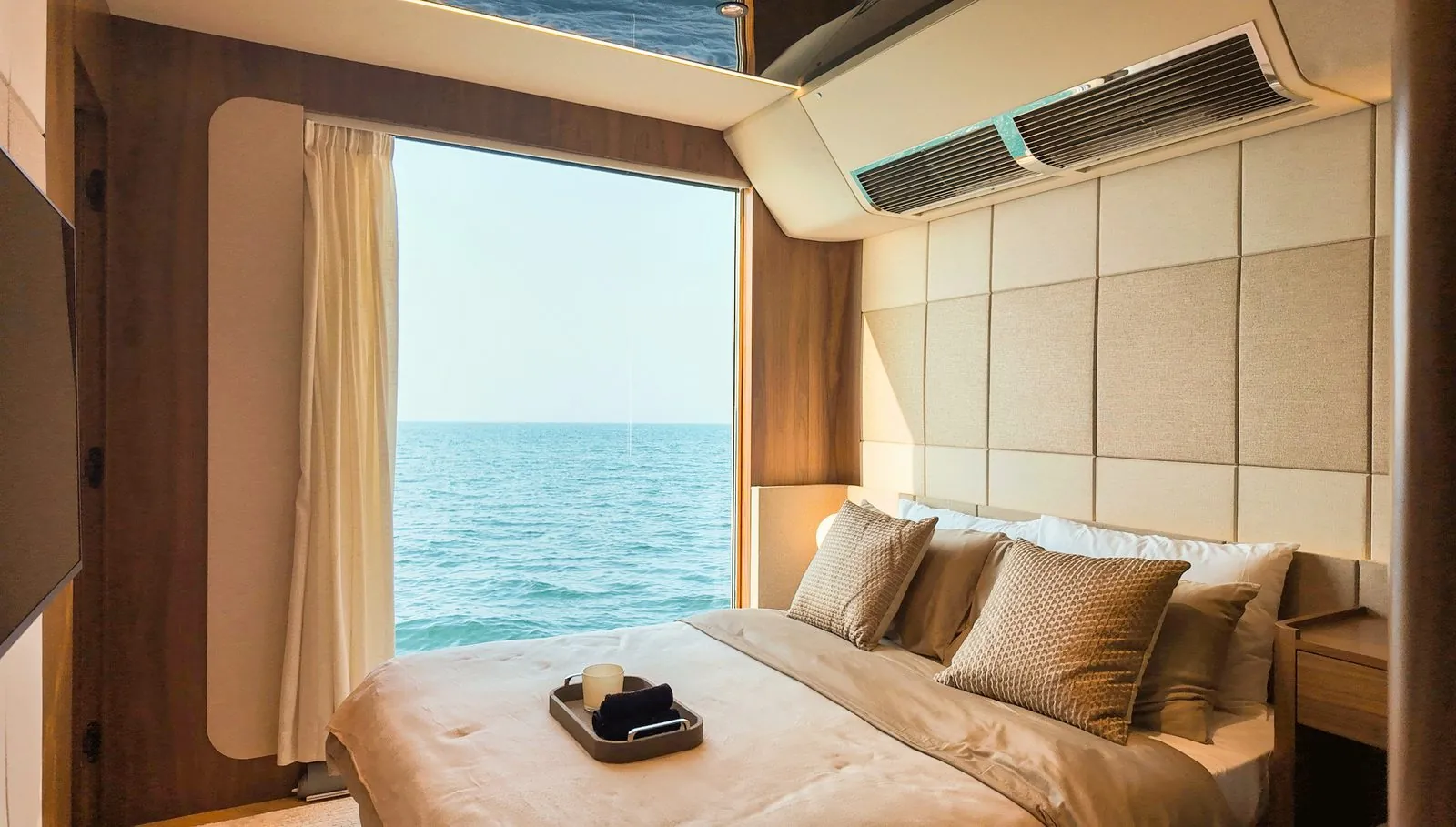 RISE 70 master suite with a queen bed facing a panoramic sea window