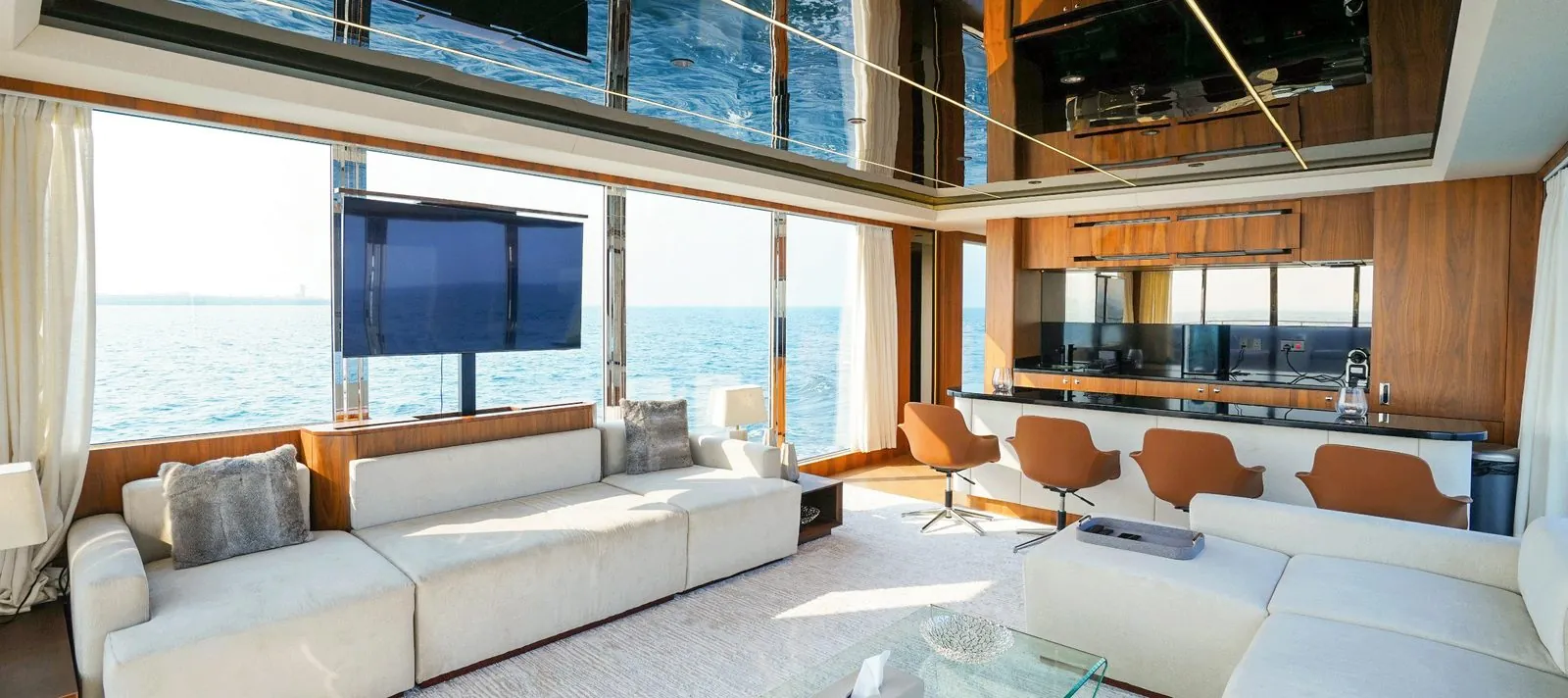 RISE 70 saloon with wrap-around sofas, a dining area and panoramic windows